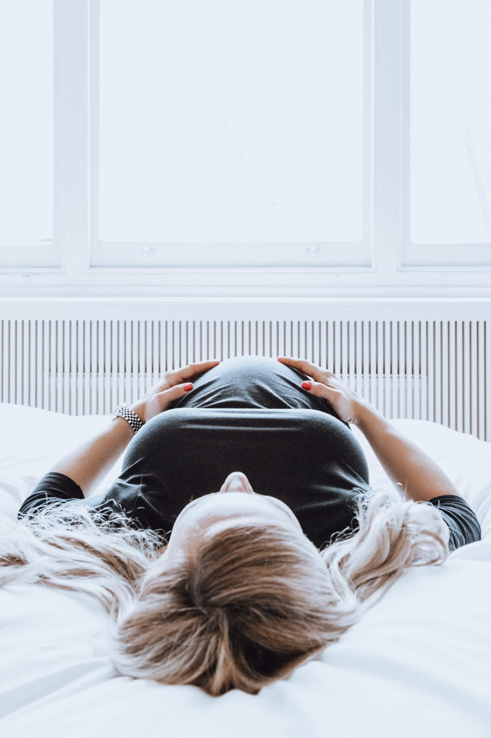 Feature image Pregnant Lady Laying on Bed