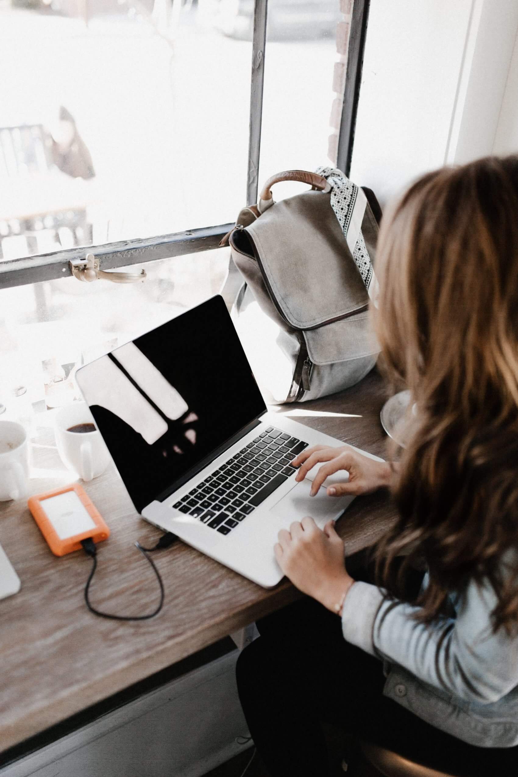 Women Charging Laptop at Cafe