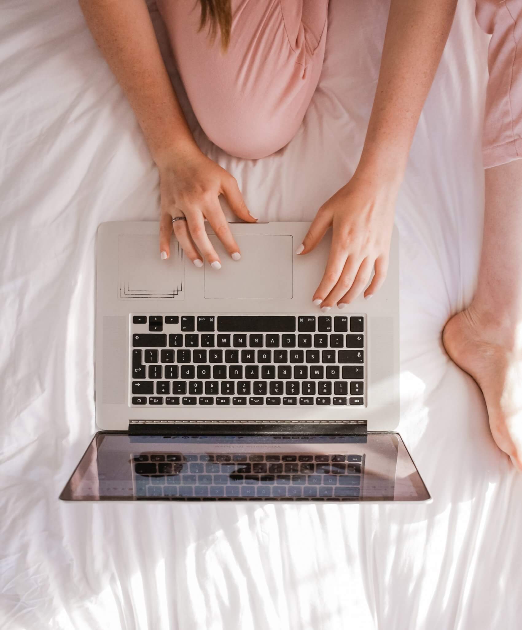 Female Sitting on Bed with Laptop